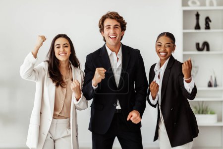 Téléchargez les photos : Des collègues d'affaires multiethniques excités célébrant le succès du travail d'équipe, les réalisations, les poings serrés et les cris de joie, des employés heureux se réjouissant ensemble de la victoire au pouvoir - en image libre de droit