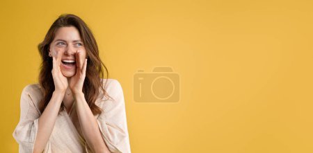 Téléchargez les photos : Positif jeune femme caucasienne dans occasionnel met les mains face à face, criant avec la bouche ouverte, isolé sur fond de studio jaune. Annonce et offre, commérages, bonnes nouvelles, mode de vie, émotions humaines - en image libre de droit