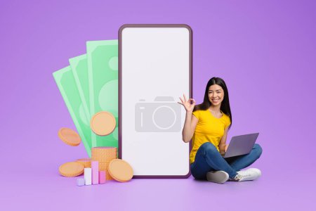 Photo for Happy millennial chinese woman trading on stocks and markets online, using gadgets laptop computer, sitting by big phone with white blank screen, collage for stock trading and investing - Royalty Free Image