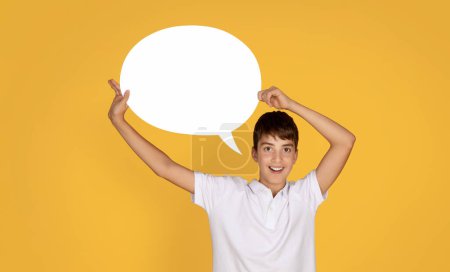 Photo for Surprised cheerful european teenage boy hold abstract cloud for thoughts at school, isolated on orange studio background. Idea for study, knowledge, ad and offer, people emotions - Royalty Free Image