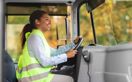 Photo for Portrait Of Beautiful Black Driver Woman Driving Public Bus, Happy Young African American Female Wearing Reflective Vest, Holding Steering Wheel And Looking On The Road, Enjoying Her Job, Side View - Royalty Free Image