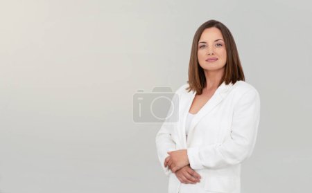 Téléchargez les photos : Entrepreneuriat. Portrait d'une femme d'affaires confiante portant une veste blanche, posant en regardant la caméra sur fond de studio gris. Lady Entrepreneur Publicité Offre d'affaires, Espace libre - en image libre de droit