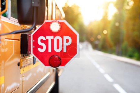 Foto de Autobús escolar amarillo con señal de stop rojo de pie en la carretera, primer plano de señal de atención con señal de luz colgando en el autobús escolar, vehículos de transporte para el concepto de los alumnos, espacio de copia - Imagen libre de derechos