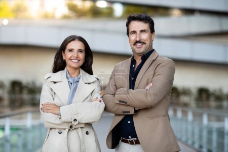 Photo for Business partners, partnership, cooperation in business. Portrait of middle aged confident business people posing outdoors, handsome mature man and elegant attractive woman next to office building - Royalty Free Image