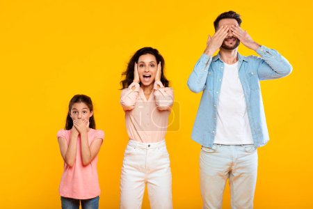 Photo for Hear no evil, see no evil, speak no evil. Family of three people covering eyes, ears and mouth, showing blind, deaf and three wise monkey scene, posing over yellow background - Royalty Free Image