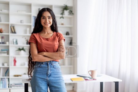 Photo for Portrait of confident attractive long-haired young indian woman wearing casual outfit posing at home office, arms crossed on chest, smiling at camera, copy space. Entrepreneurship, remote job - Royalty Free Image