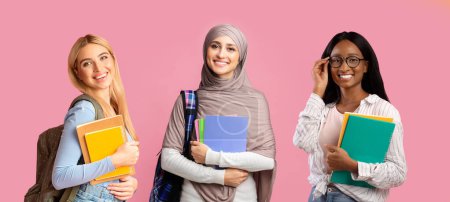Foto de Tres estudiantes femeninas multiétnicas que llevan mochilas y libros de trabajo posando sobre fondo rosa, grupo de mujeres jóvenes alegres sonriendo a la cámara mientras están de pie sobre el telón de fondo colorido, collage - Imagen libre de derechos