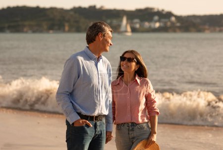 Photo for Portrait Of Loving Mature Spouses Walking Together Near The Sea, Romantic Middle Aged Man And Woman Holding Hands And Smiling, Happy Couple Promenading On The Beach, Enjoying Vacation Time - Royalty Free Image