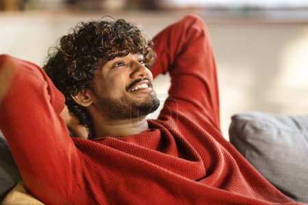 Photo for Relax Concept. Happy Young Indian Man Leaning Back On Sofa At Home, Smiling Handsome Eastern Male Resting On Couch With Hands Behind Back, Millennial Guy Daydreaming In Living Room, Closeup - Royalty Free Image