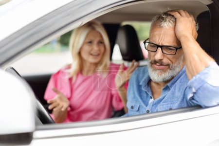 Téléchargez les photos : Homme âgé stressé portant des lunettes assis dans la voiture, toucher sa tête, se battre avec sa femme. Conjoints aînés discutant de la route pendant un voyage en automobile, des difficultés dans le mariage, des relations - en image libre de droit