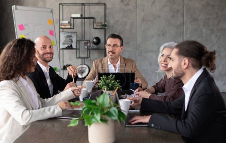 Téléchargez les photos : Équipe d'affaires professionnelle élaborant des stratégies lors d'une réunion réunie autour d'une table dans un bureau moderne, souriant engagé dans la planification stratégique, mettant en valeur le travail d'équipe et les entreprises prospères - en image libre de droit