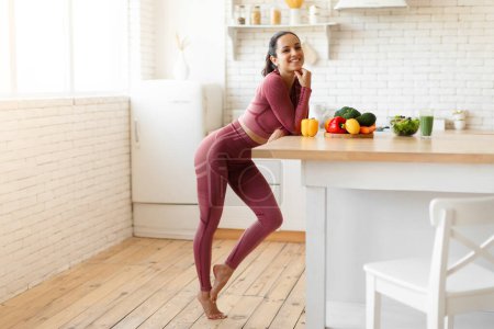 Photo for Full Length Shot Of Fitness Woman Posing Near Dining Table With Vegetables At Home Kitchen Interior, Smiling To Camera. Nutrition Specialist Young Lady Advertising Healthy Eating Habits - Royalty Free Image