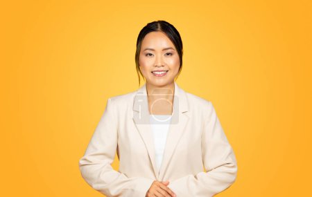 Photo for Bright, eye-catching portrait of smiling millennial Asian lady, exuding positivity and vitality, set against lively yellow background. Her joyful demeanor captures essence of youthful exuberance - Royalty Free Image