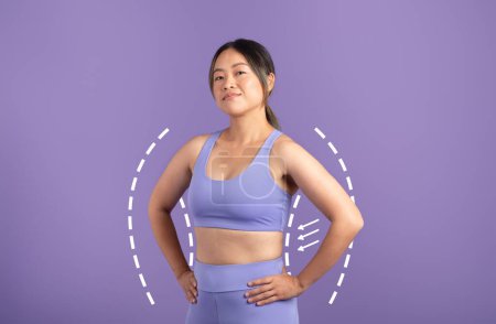 Téléchargez les photos : Femme asiatique en vêtements de sport, à l'intérieur silhouette dessinée, montrant son triomphe perte de poids et la promotion d'un mode de vie sain sur fond de studio violet - en image libre de droit