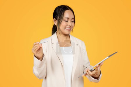 Photo for Woman smiling with stylus, show creativity and design, planning on tablet, organization and productivity, holding tablet, isolated on yellow background, modern work and technology - Royalty Free Image