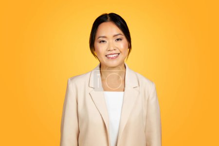 Photo for Positivity Asian millennial woman, heartfelt smile to camera. Joy becomes infectious against contrasting, bold orange background in professional studio, lifestyle and people emotions - Royalty Free Image
