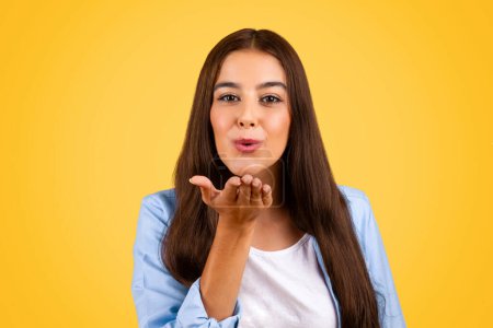 Photo for Headshot of glad pretty young student woman make air kiss gesture with hand, enjoy lifestyle, isolated on yellow studio background, close up. Flirt, love and romantic, ad and offer - Royalty Free Image