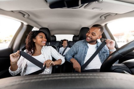 Photo for Safe Ride. Happy african american family young parents and son enjoying car journey together. Black mother looking at father while fasten seatbelt, getting ready for trip, family weekend - Royalty Free Image