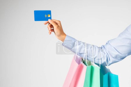 Photo for Hand of young european woman holding many shopping bags, credit card, enjoying shopping, isolated on gray background studio background, cropped. Huge sale, finance, fashion - Royalty Free Image
