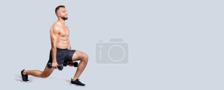 Foto de Sudor positivo fuerte musculoso milenario europeo con barba, torso desnudo hacer ejercicios con pesas, sentadillas, aislado sobre fondo gris estudio. Entrenamiento de fuerza, cuidado corporal - Imagen libre de derechos