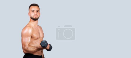 Photo for Confident calm sweat handsome strong muscular young caucasian guy with beard, naked torso make exercises with dumbbell, enjoy strength workout, isolated on gray studio background, panorama - Royalty Free Image