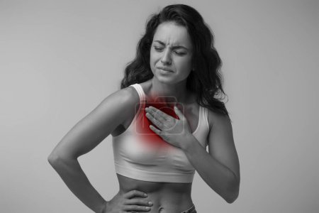 Photo for Breathing problem, heart attack. Millennial woman with chest pain touching her breast, black and white photo with inflamed red zone - Royalty Free Image