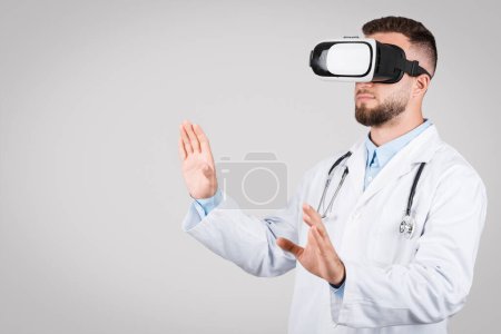 Téléchargez les photos : Médecin masculin européen concentré immergé dans un environnement de réalité virtuelle, naviguant habilement à travers des données médicales ou une procédure simulée avec précision et soin, espace libre - en image libre de droit