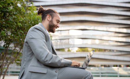 Photo for Outdoor Office. Happy Young Businessman Working With Laptop Outside Against Modern Urban Building, Handsome Male Entrepreneur Answering Emails, Millennial Man Enjoying Remote Work, Copy Space - Royalty Free Image