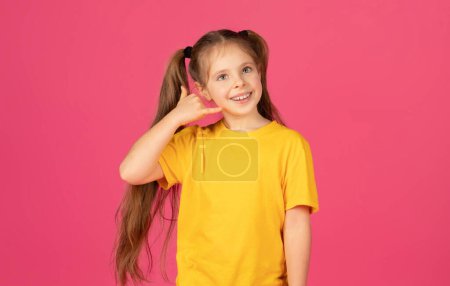 Photo for Make Call. Preteen Little Girl With Hand Near Ear Imitating Phone And Looking At Copy Space, Happy Female Child Inviting For Communication While Standing Isolated On Pink Studio Background - Royalty Free Image
