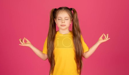 Photo for Calm preteen girl meditating with closed eyes, relaxed female kid standing isolated on pink studio background, kid practicing yoga and making zen mudra gesture with hands, copy space - Royalty Free Image