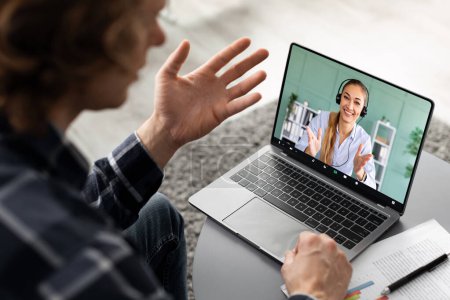 Photo for Distance Communication. Guy Making Video Call On Laptop With Young Lady Consultant, Communicating Online At Home, Back View. Unrecognizable Freelancer Talking To Advisor. Selective Focus, High-Angle - Royalty Free Image