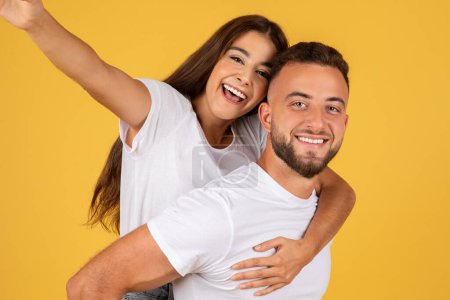Photo for Glad millennial european lady in white t-shirts have fun, enjoy date, hugs, make selfie on phone, isolated on yellow studio background, close up. Relationships and love, photo for blog, lifestyle - Royalty Free Image