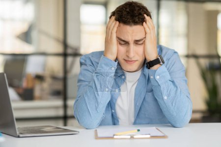Photo for Sad tired despaired young european man manager hold head with hands, suffer from mistake, problems at table in coworking office. Stress at work, business, deadline, first day at bad job - Royalty Free Image