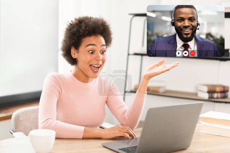 Photo for Glad surprised millennial african american business lady has video call gesturing, look at laptop webcam, sitting at table in office interior. Business, work, meeting remotely and social distancing - Royalty Free Image