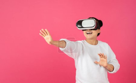 Photo for Excited young asian woman using VR glasses, touching something invisible at copy space, millennial female experiencing ar virtual reality adventure on bright pink studio background, panorama - Royalty Free Image