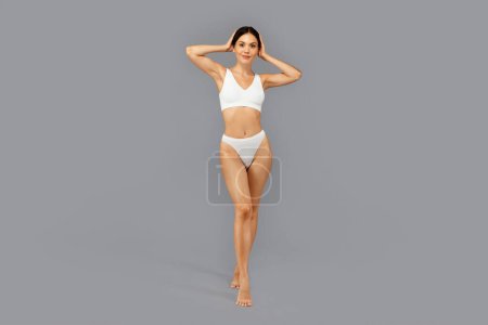 Photo for Happy european slim millennial woman in white underwear with perfect body, enjoy body care, isolated on gray studio background, full length. Beauty care and lifestyle, weight loss - Royalty Free Image