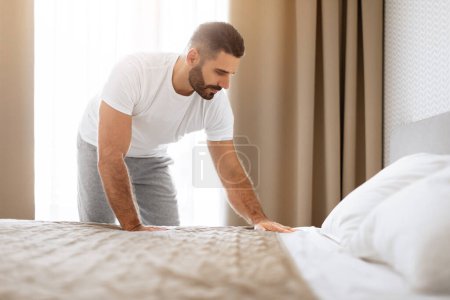 Photo for Good Morning. Rested Middle Aged Man Making His Bed After Sleep, Tidying His Modern Cozy Bedroom, Starting Day With Self Discipline Rituals. Comfort and Care Concept - Royalty Free Image