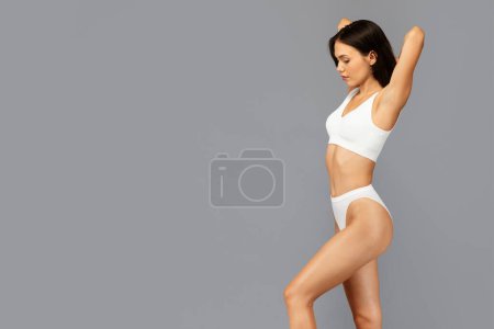 Photo for Profile of calm asian millennial woman in white underwear, show healthy figure and strength, enjoy body care, weight loss, isolated on grey background. Health and fit lifestyle - Royalty Free Image