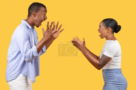 Photo for Black man and woman engage in playful gestures with exaggerated surprised expressions, creating humorous and lively scene on vivid yellow background - Royalty Free Image