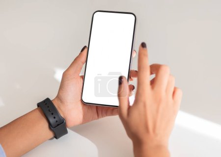 Téléchargez les photos : Close up of hands holding a smartphone with a blank screen, showcasing a smartwatch on the wrist, suggesting a modern and connected lifestyle, enjoy lifestyle, website, shopping - en image libre de droit