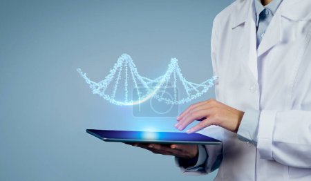 La experiencia cumple con la tecnología: la toma de cerca del médico maneja CRISPR y la realidad aumentada para decodificar los secretos del ADN virtual para los pacientes en la tableta digital, el fondo azul del estudio, el espacio libre