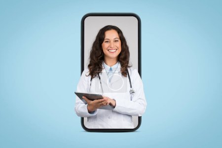 Cita con doc en línea. Alegre médico femenino con almohadilla digital y estetoscopio en la pantalla del teléfono inteligente enorme, aislado en el fondo azul, collage