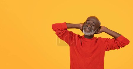 Téléchargez les photos : Détendu et content homme afro-américain senior en pull rouge, les mains derrière la tête, profitant d'un moment de paix et de bonheur sur un fond jaune vif, studio - en image libre de droit