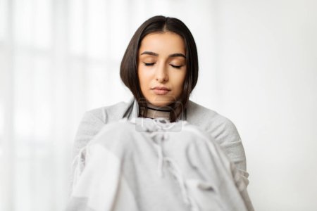 Photo for Tranquil unhappy young middle eastern woman in casual home attire, with a serene expression, enjoys a quiet moment to herself while holding a soft, cozy blanket, suffer from flu - Royalty Free Image