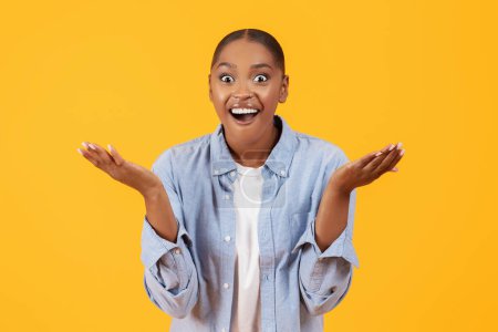 Téléchargez les photos : Portrait de jeune femme noire criant OMG se sentant excité, exprimant l'émotion de joie sur fond de studio jaune. Offre WOW incroyable, nouvelles choquantes, concept de vente énorme - en image libre de droit
