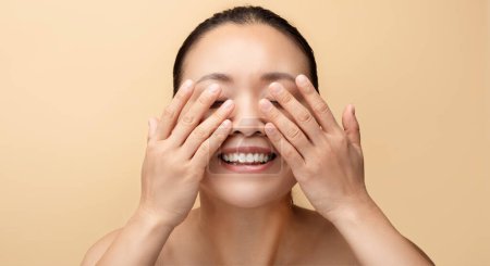 Photo for Glad millennial korean naked woman wash face, cleaning skin with hands, isolated on beige background, studio, panorama, close up. Natural beauty care, routine treatment at home - Royalty Free Image