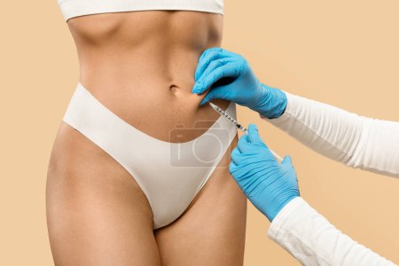 Photo for Fat Dissolving Injections. Unrecognizable Doctor Making Lipolysis Shot With Syringe To Female Belly, Young Female In Underwear Getting Slimming Treatment By Professional Beautician, Cropped - Royalty Free Image