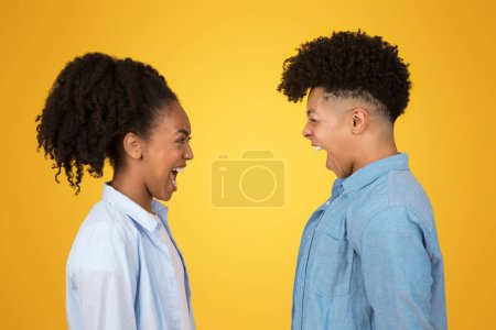 Traurig wütende junge Afroamerikaner in lässiger Kleidung lachen herzlich von Angesicht zu Angesicht vor einem leuchtend gelben Hintergrund und fangen einen Moment schlechter Verbindung ein, Nahaufnahme, Profil