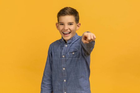 Photo for Gotcha. Positive Teen Boy Pointing Finger At Camera And Laughing, Portrait Of Cheerful Teenage Male Child Indicating Somebody While Standing Isolated On Yellow Studio Background, Copy Space - Royalty Free Image
