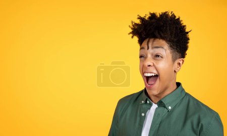 Photo for Excited stylish handsome millennial black guy looking at blank copy space for advertisement and screaming, checking amazing offer or deal, panorama, yellow studio background - Royalty Free Image